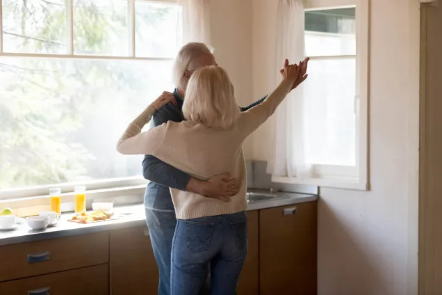 couple aux cheveux blancs dansant dans la cuisine